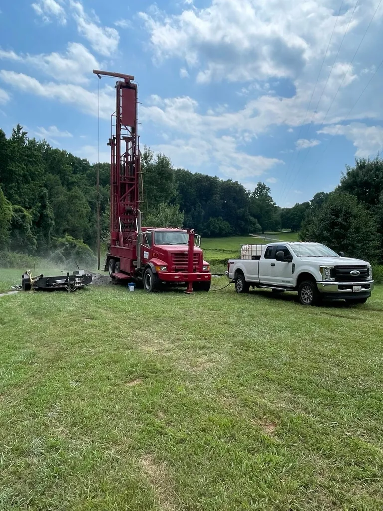 HydroWells drill rig and service truck drilling a well on a Maryland property