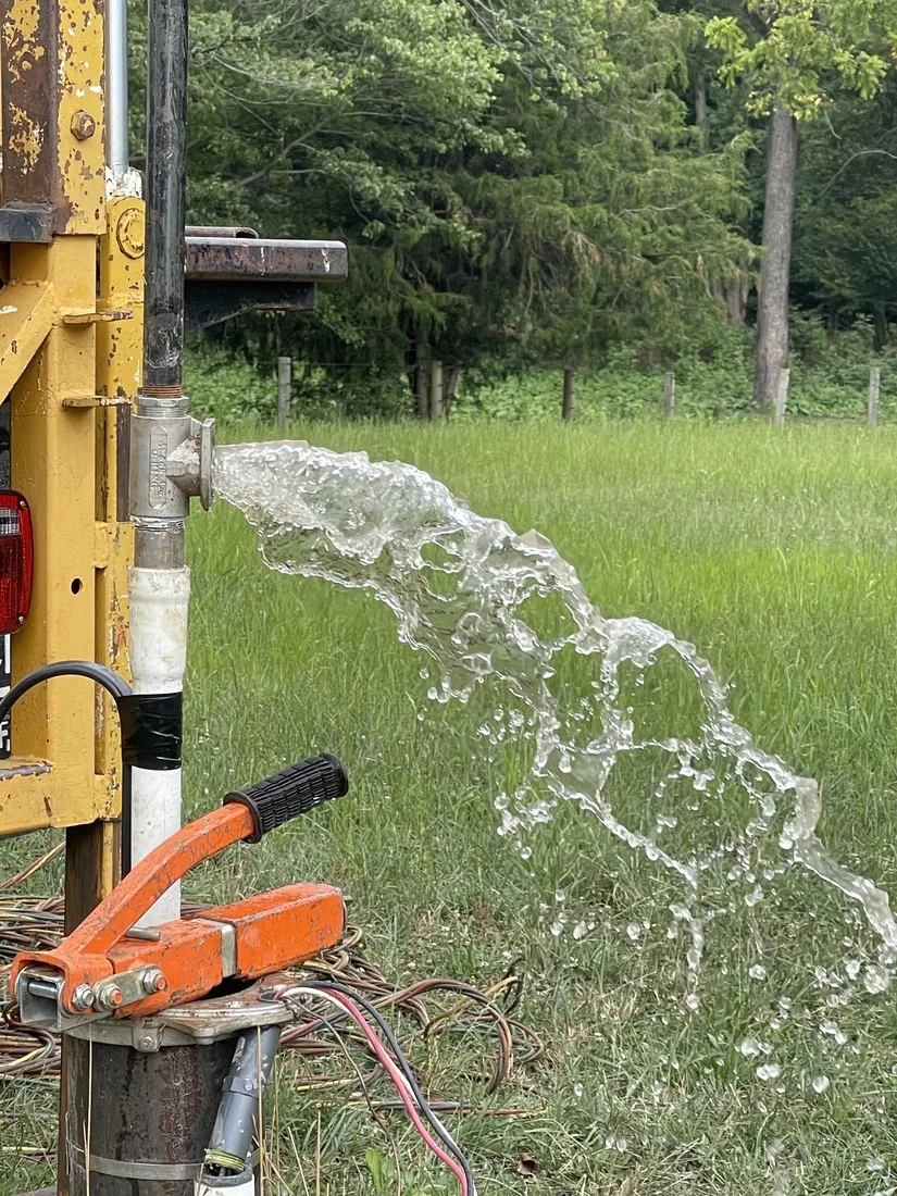 Water surging from a casing during well development